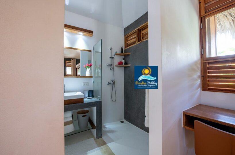 Baño moderno con ducha, lavabo y decoración tropical en Las Terrenas, República Dominicana.