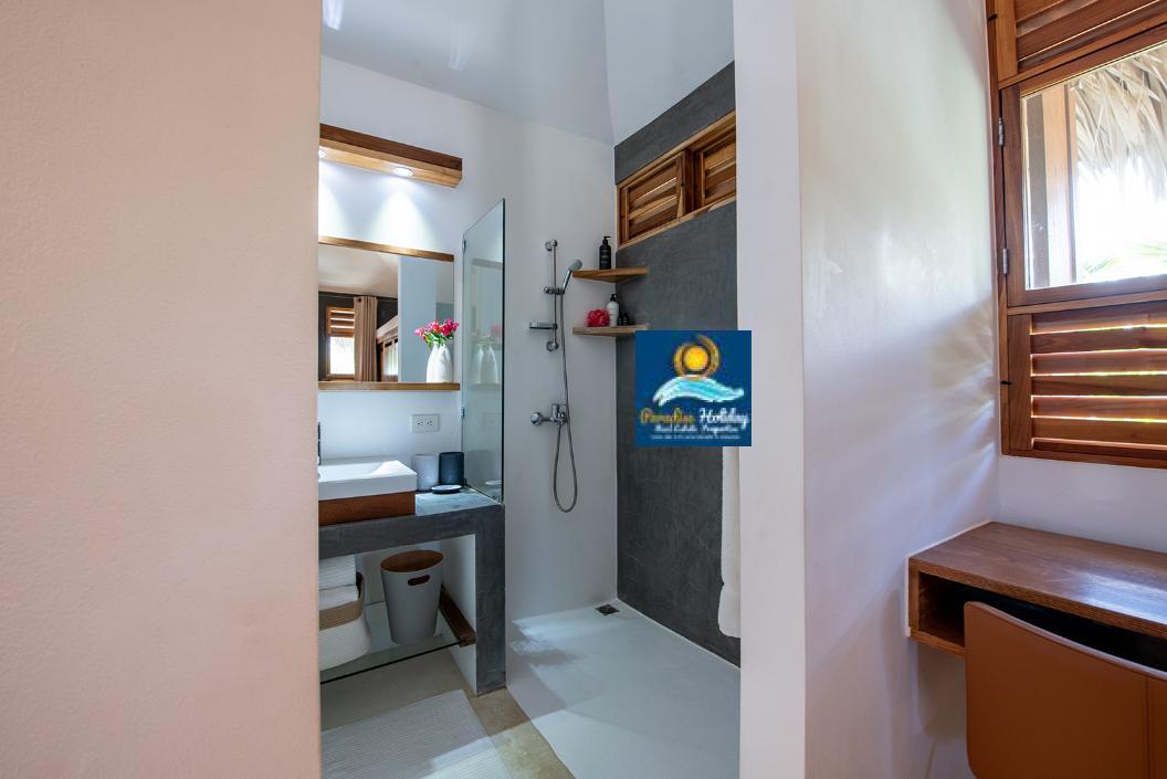 Baño moderno con ducha, lavabo y decoración tropical en Las Terrenas, República Dominicana.