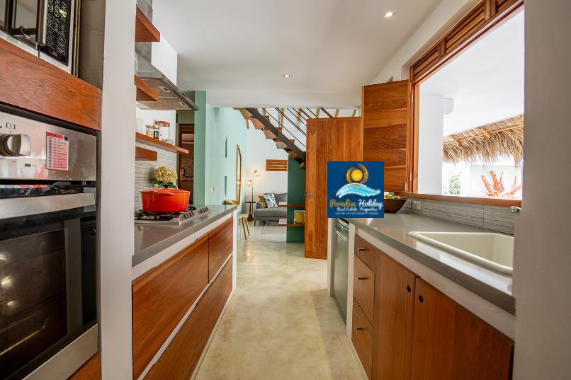 Cocina moderna con electrodomésticos y vistas al mar.