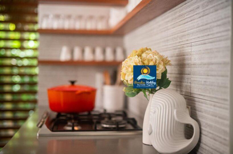 Cocina moderna en Las Terrenas con flores decorativas y utensilios en un ambiente acogedor.