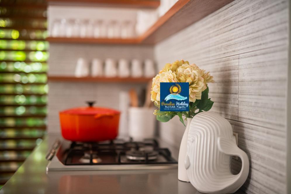 Cocina moderna en Las Terrenas con flores decorativas y utensilios en un ambiente acogedor.