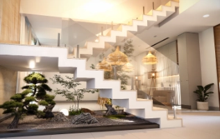 Vista moderna de interior con escalera flotante y jardín zen en Las Terrenas.