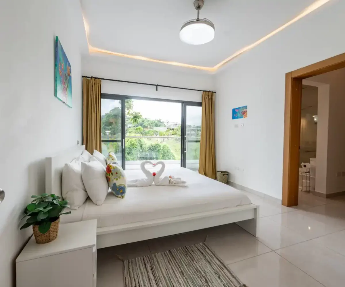 Habitación luminosa con cama doble, decorada con detalles tropicales y vista al exterior en Las Terr.