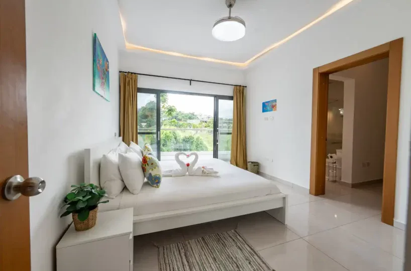 Habitación luminosa con cama doble, decorada con detalles tropicales y vista al exterior en Las Terr.