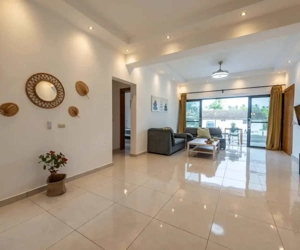 Apartamento amplio y luminoso en Las Terrenas, con sala de estar moderna y acceso a balcón con vista.