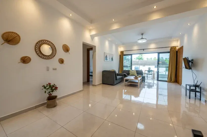 Apartamento amplio y luminoso en Las Terrenas, con sala de estar moderna y acceso a balcón con vista.